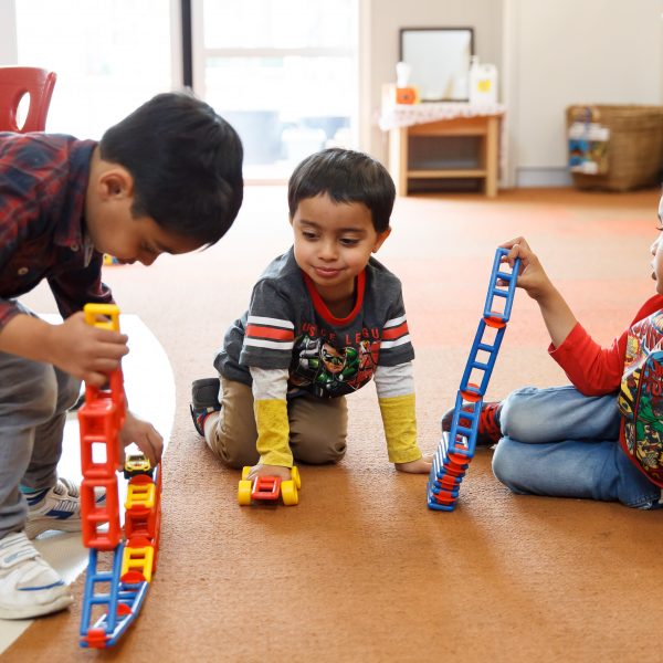 3 young boys playing with connector blocks