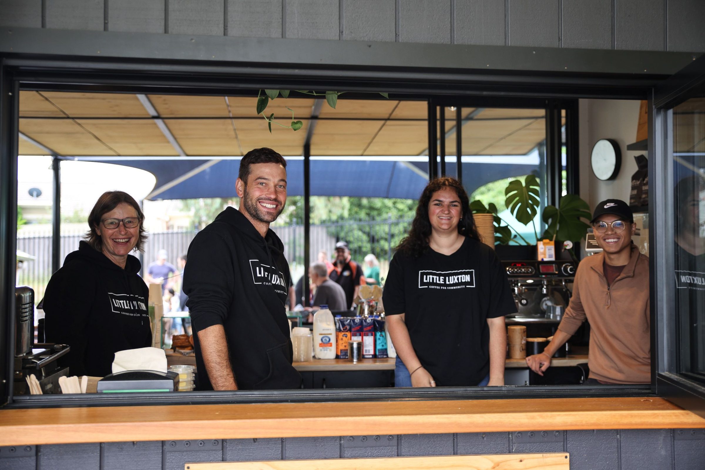 Staff from social enterprise cafe Little Luxton face the camera with smiles