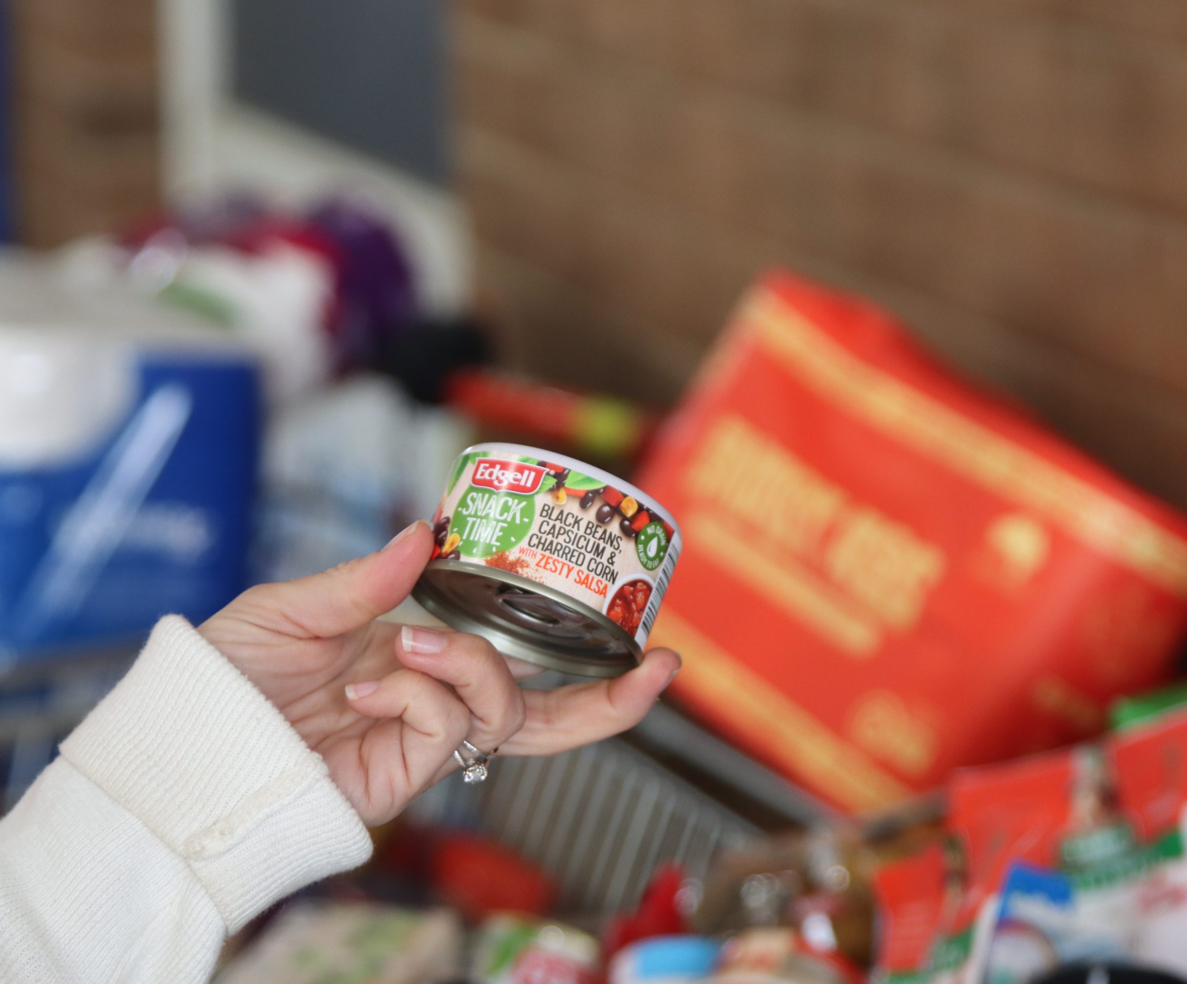 Female hand holding a can of beans